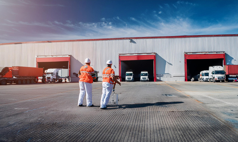 Why Reliable Freight Transport is Essential for the U.S. Supply Chain 3 warehouse dock with workers loading trucks